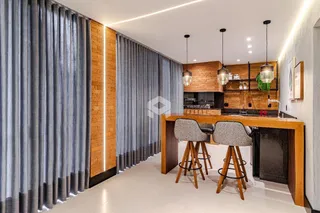 Vista de uma cozinha moderna com ilha e paredes de tijolo aparente.