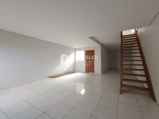 Ambiente interno com piso de cerâmica e paredes brancas.