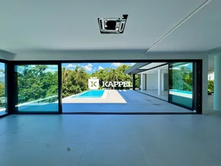 Sala de estar com vista para piscina e jardim em Lajeado.