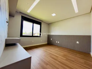 Sala de estar com piso de madeira e janela grande.