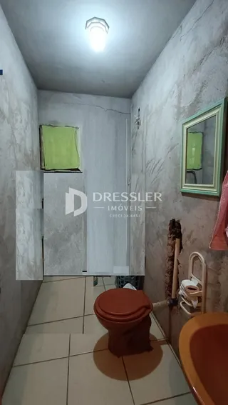 Foto de um corredor interno com paredes brancas e piso de cerâmica.