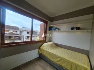 Quarto com grande janela de vista para a rua.