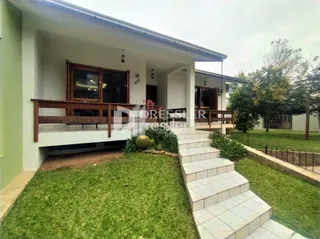 Fachada de uma residência em Lajeado, Brasil, com jardim frontal e varanda.