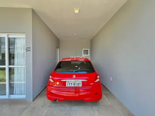 Vista do corredor de uma propriedade em Lajeado, Brasil, com um carro vermelho estacionado.