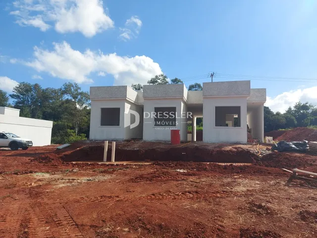 Fachada de uma casa em construção no terreno.