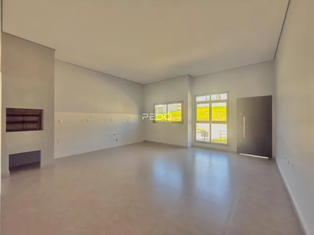 Ambiente interno de uma sala ampla e clara com piso de cerâmica.