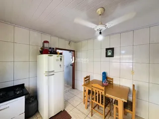 Foto de uma sala com mesa de jantar de madeira e geladeira branca.
