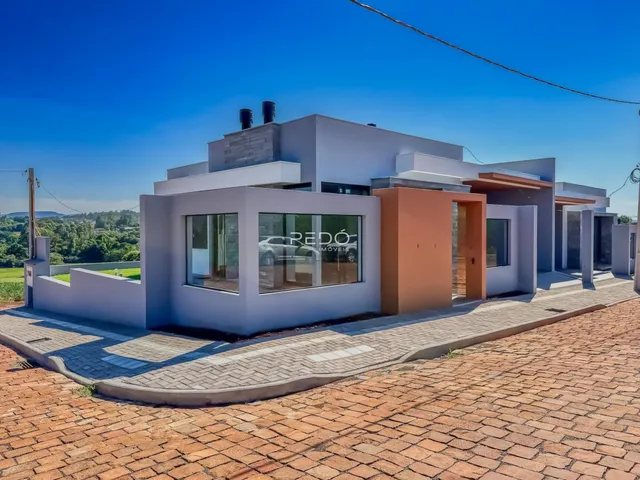 Fachada de uma casa moderna em Lajeado, Brasil, com jardim e área pavimentada.