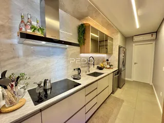 Cozinha moderna com armários e bancadas de mármore.