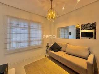 Sala de estar com sofá e janelas em um imóvel no Brasil.