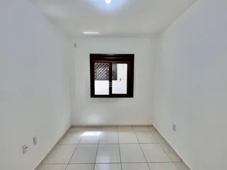 Corredor interno com piso de cerâmica e parede branca.