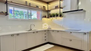 Uma cozinha com armários brancos e bancadas claras.