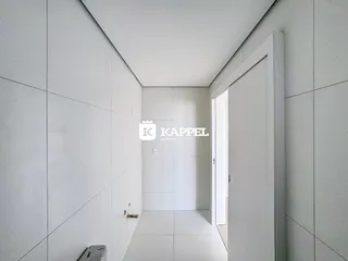 Hall de corredor com paredes brancas e piso claro.