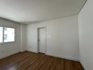 Foto de um cômodo interno com piso de madeira e uma janela.