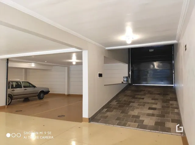 Corredor interno de uma residência com piso de cerâmica clara.