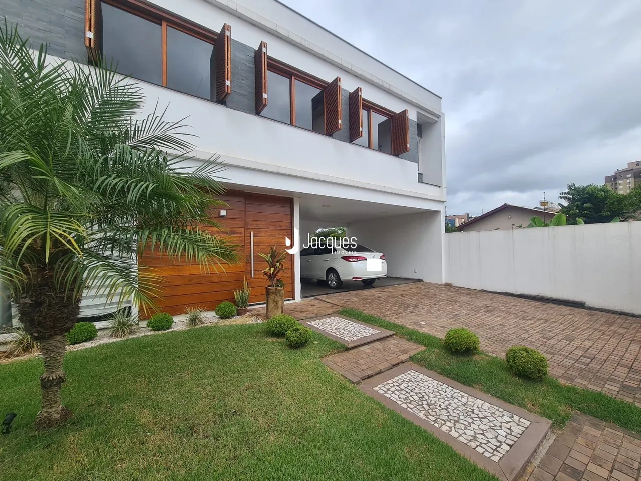 Fachada de uma casa moderna em Lajeado, Brasil, com jardim e garagem.