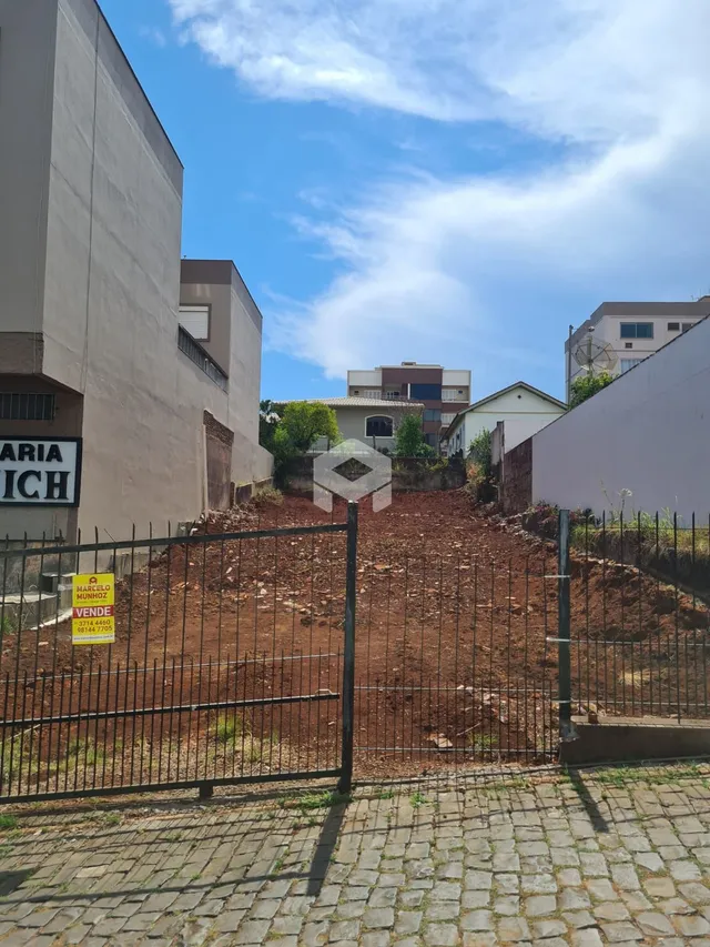 Vista externa da propriedade mostrando o muro e a cerca de arame.