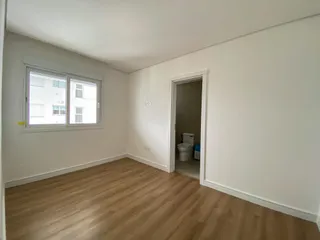 Esta é uma sala de estar com piso de madeira e uma janela.