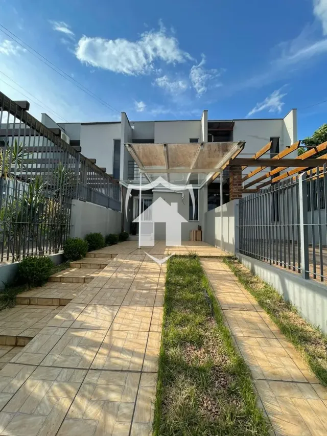 Vista da fachada de uma residência em Lajeado, Brasil, com área externa pavimentada.