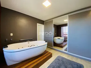 Uma foto de um banheiro moderno com banheira de imersão e piso de madeira.