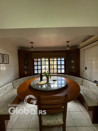 Sala de jantar com mesa de madeira e assentos estofados.