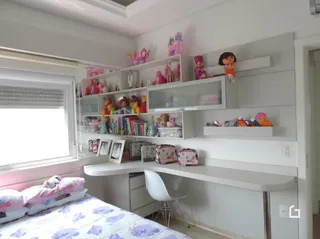 Quarto com cabeceira e estantes brancas em um imóvel no Brasil.