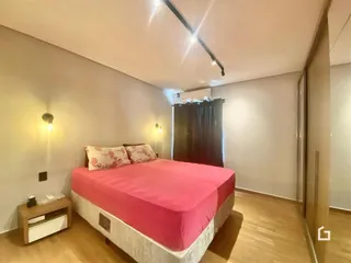 Quarto com cama e piso de madeira.