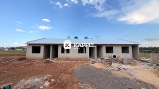 Fachada de uma construção residencial em estágio inicial com telhado de metal.
