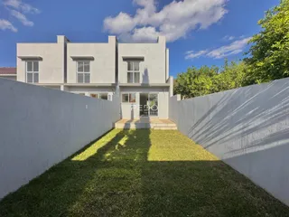 Fachada de uma casa moderna em Lajeado, Brasil, cercada por muros brancos.