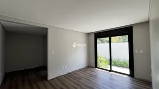 Interior de uma sala com piso de madeira e porta de vidro.