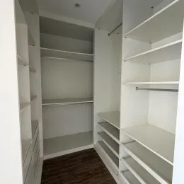 Prateleiras brancas em um ambiente interno com revestimento de parede.