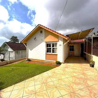 Fachada de uma casa em Lajeado, Brasil, com jardim e área pavimentada.