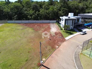 Vista externa do terreno com gramado e área de acesso ao imóvel.