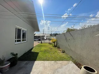 Vista da fachada de uma casa em Lajeado, Brasil, com jardim gramado e muro lateral.
