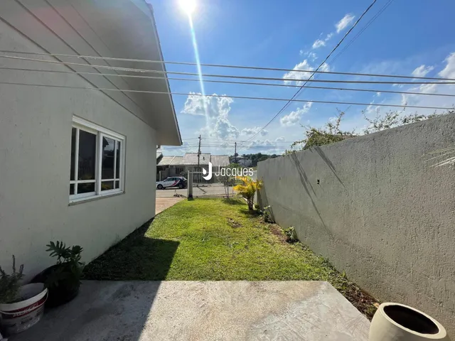 Vista da fachada de uma casa em Lajeado, Brasil, com jardim gramado e muro lateral.