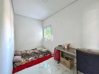 Quarto com cama e janela em uma residência.