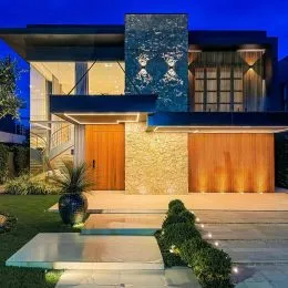 Fachada moderna de uma residência em Lajeado, Brasil, com revestimento azul e madeira.