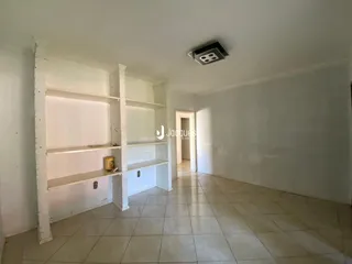 Corredor interno com paredes brancas e piso de cerâmica.