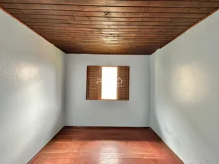 Vista interna de um cômodo com piso de madeira e teto de madeira.