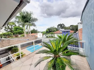 Varanda com vista para piscina e vegetação tropical.