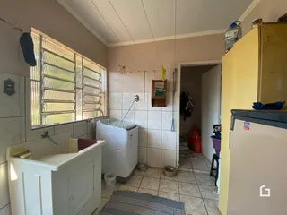Foto de um banheiro com revestimento cerâmico branco e tanque.