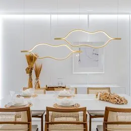 Mesa de jantar posta com toalhas brancas em um ambiente interno.