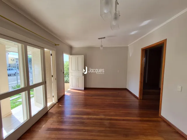 Interior de uma sala com piso de madeira e portas de vidro.