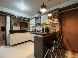 Imagem de uma cozinha moderna com armários escuros e bancadas claras.