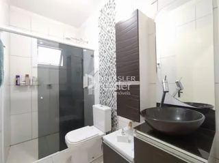 Banheiro com revestimento branco e louças modernas.