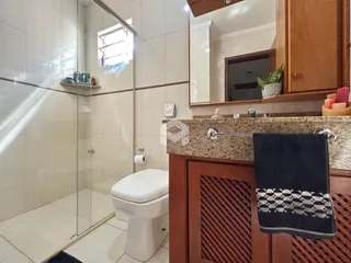 Foto de um banheiro com box de vidro e piso cerâmico.
