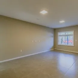 Ambiente interno amplo com paredes claras e piso liso.