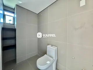 Foto de um banheiro com revestimento de cerâmica e vaso sanitário branco.