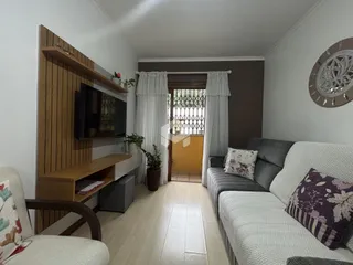 Sala de estar com decoração moderna e piso de madeira clara.