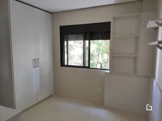 Quarto interno com armários embutidos e janela grande.